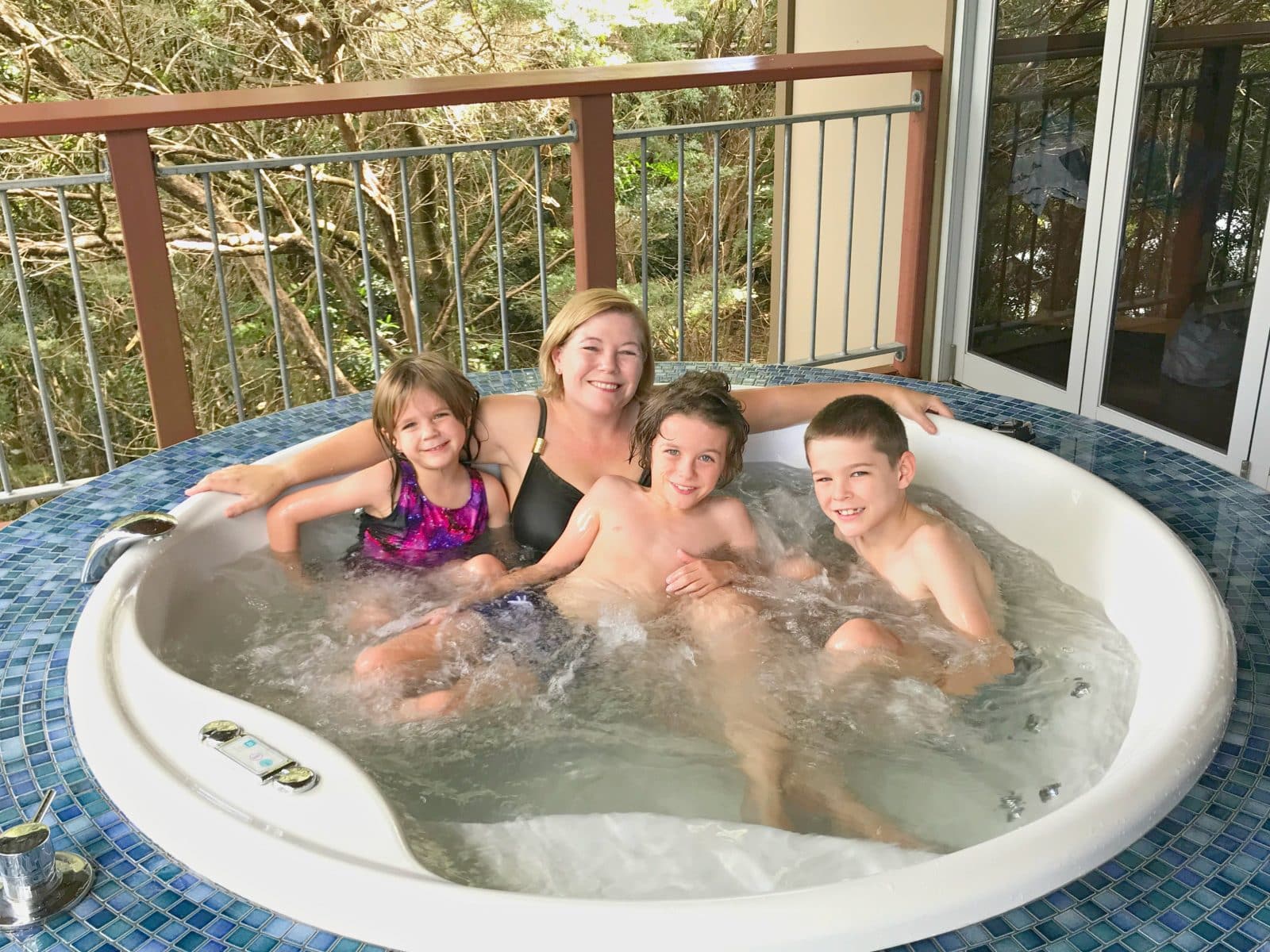 A family in a hot tub at O'reilly's Rainforest Retreat accommodation