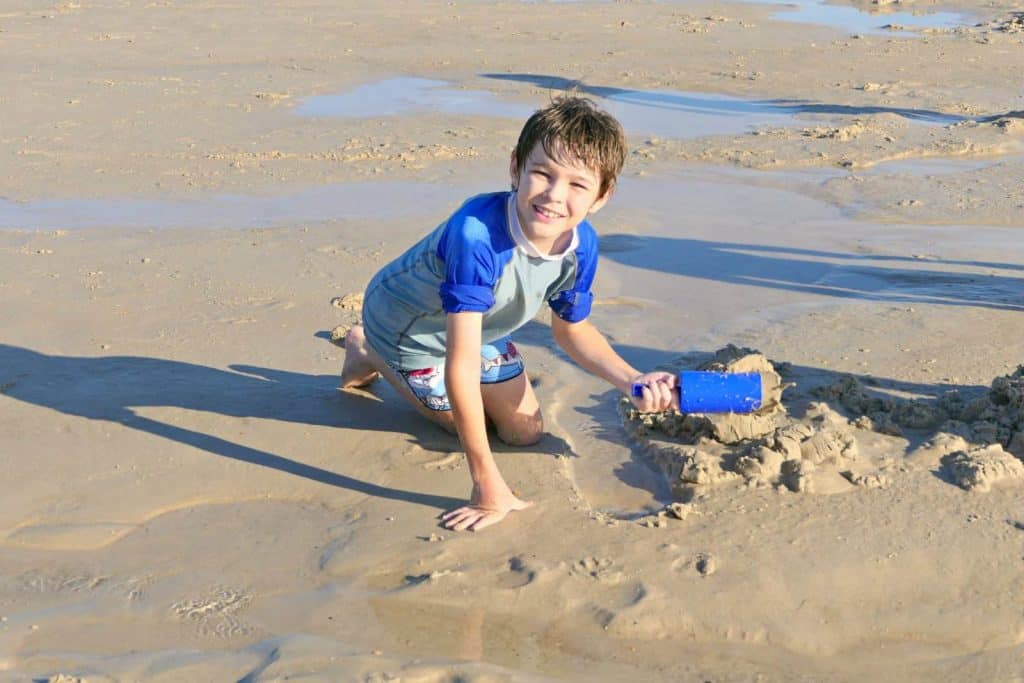 A boy on the beach wearing sunscreen