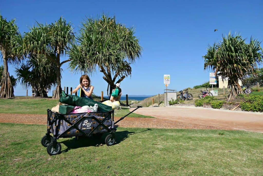 A girl with a Buddy Wagon beach cart at the beach