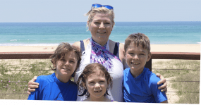 A mum and three kids by the beach