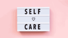 The words self care with a pink background