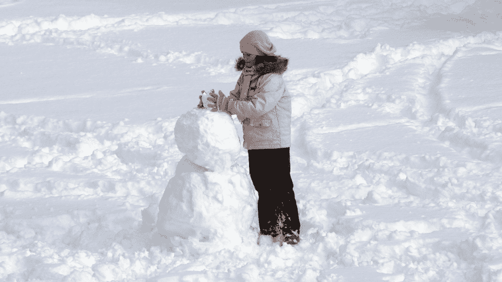 A girl building a snowman in Australia's snow