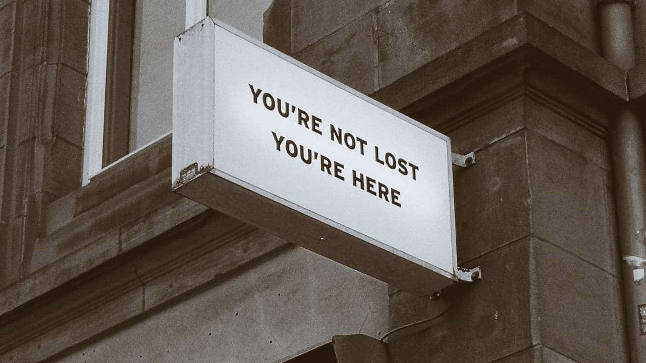A sign that says 'you're not lost you're here'.